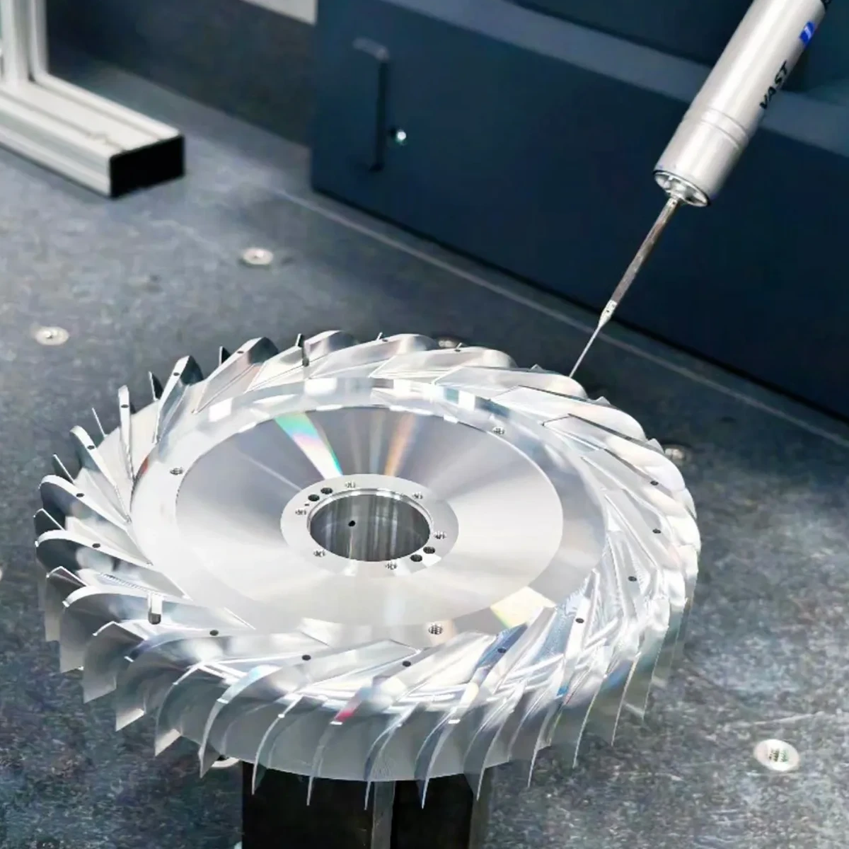 Coordinate measuring probe inspecting the curved blades of a machined metal impeller